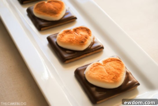 Process shot: Heart shaped marshmallows and chocolate on graham crackers before broiling for S'more Cookies.