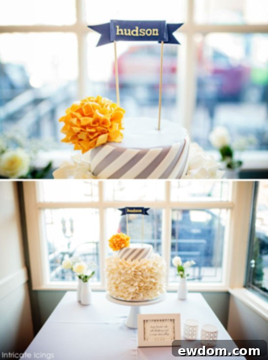 Close-up of the charming yellow pom-pom detail and a darling personalized sugar name banner for Baby Hudson on the baby shower cake.