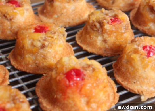 Batch of Pineapple Upside-Down Cupcakes cooling on a wire rack after being inverted from the pan