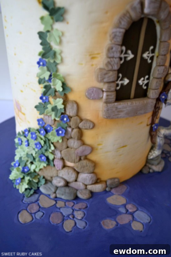 Close-up of Rapunzel's long, golden braid cascading down the cake tower.