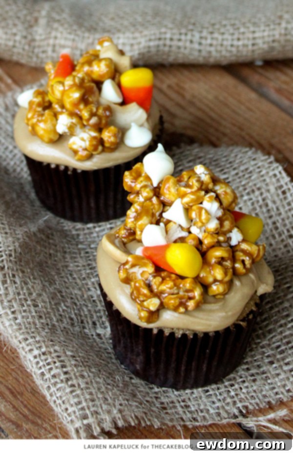 Sweet & Salty Popcorn Cupcakes 3 Close-up of a decorated Caramel Corn Cupcake featuring fluffy caramel frosting and golden caramel popcorn with candy corn accents