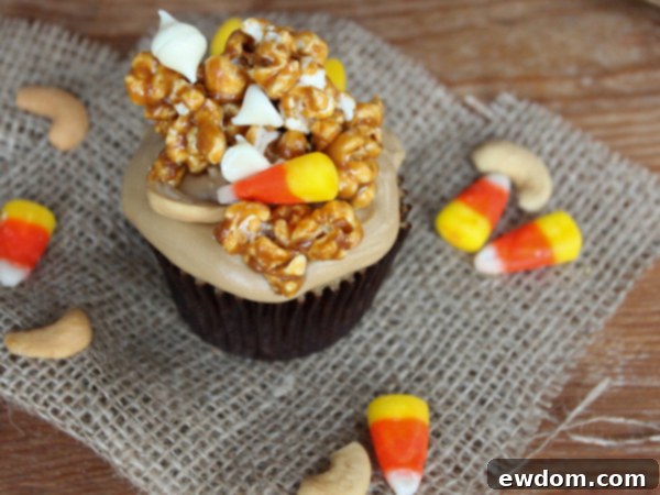 Sweet & Salty Popcorn Cupcakes 7 Three beautifully presented Caramel Corn Cupcakes, showcasing the layers of cake, frosting, and the delicious caramel corn topping with its colorful mix-ins