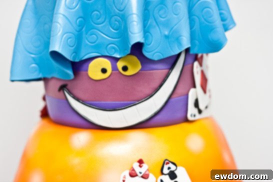 Cheshire Cat detail on Wonderland Cake by Dream Day Cakes, perched on an orange mushroom