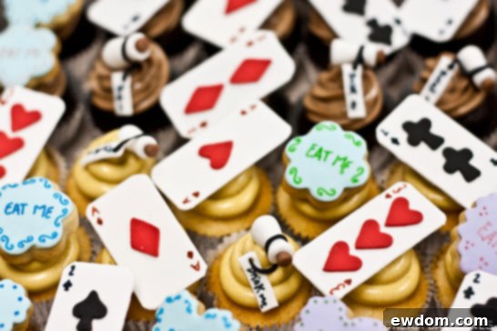 Mini cupcakes with 'Eat Me' and 'Drink Me' toppers, perfect for an Alice in Wonderland theme