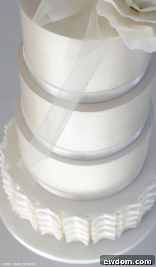 Close-up of Pleated Tier and Lustred White Wedding Cake by Cove Cake Design