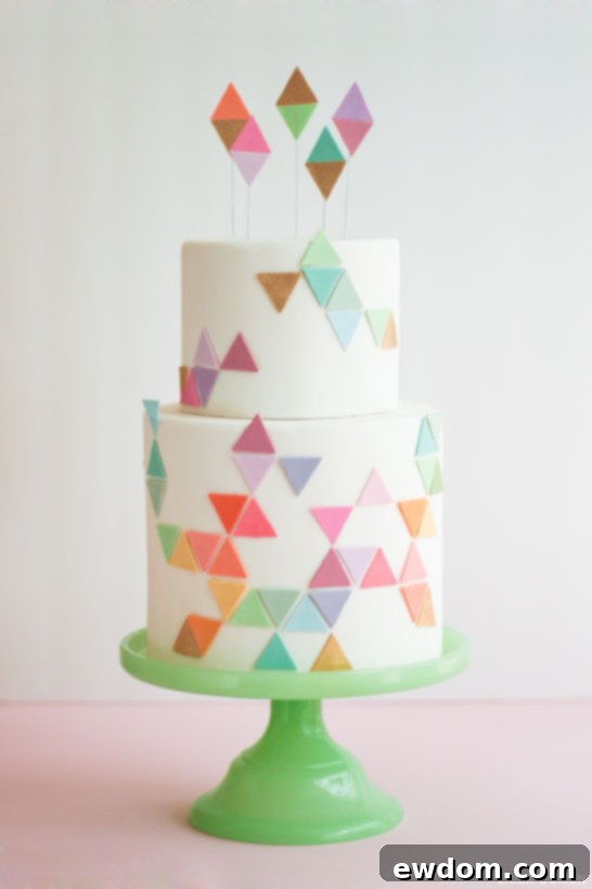 Close-up of geometric cake design with pastel triangles and gold accents, showing intricate fondant work