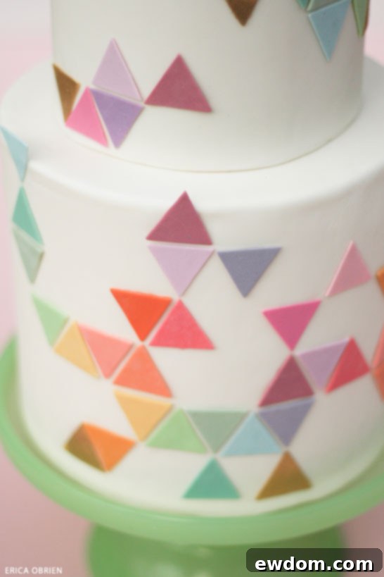 Geometric pastel cake with edible toppers inserted at different heights, creating dynamic interest