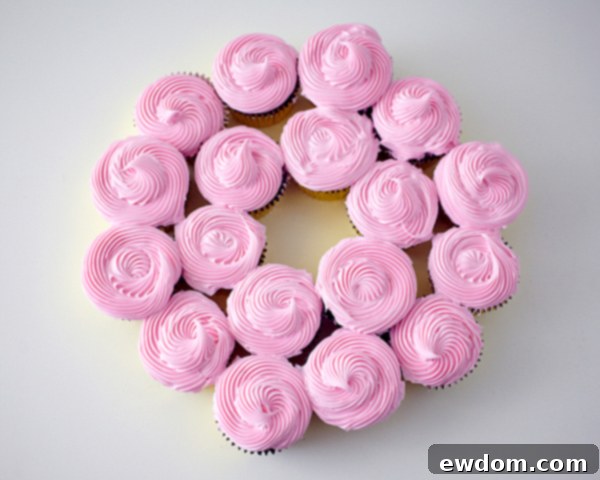 Arranging cupcakes into a stunning Christmas wreath shape on a platter