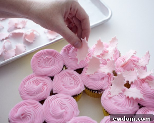 Adding delicate fondant leaves to your Christmas Cupcake Wreath for texture