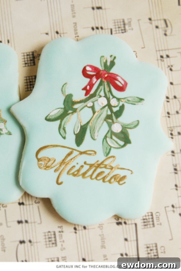 Close-up of stencil-painted mistletoe cookies showcasing detailed artistry