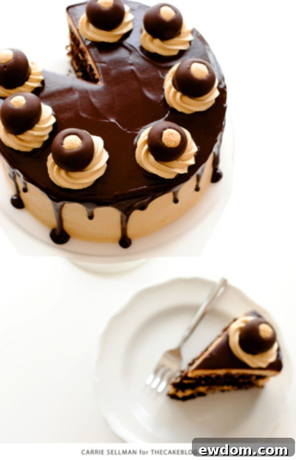 Hand dipping a peanut butter ball into melted chocolate