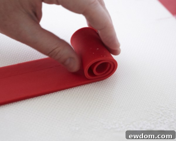 Valentines Candy Heart Surprise Cake 23 Gently applying a red fondant strip around the side of the heart cake lid