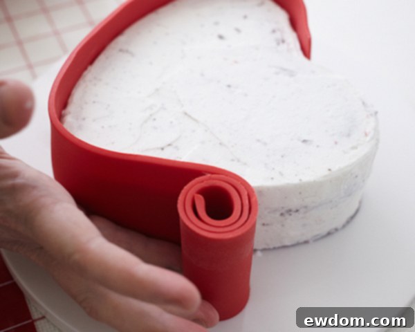 Valentines Candy Heart Surprise Cake 25 Applying a taller red fondant strip to the side of the 'candy box' cake base