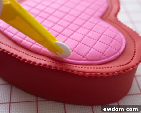 Valentines Candy Heart Surprise Cake 33 Finishing the edges of the quilted hot pink fondant heart with a plain wheel tool