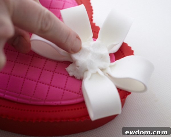Valentines Candy Heart Surprise Cake 37 Inserting dried fondant bow loops into the sticky fondant base on the cake lid