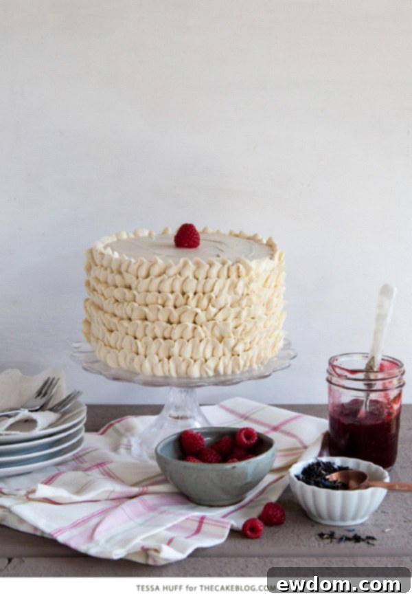 Two slices of Raspberry Earl Grey Cake with fresh raspberries on a plate