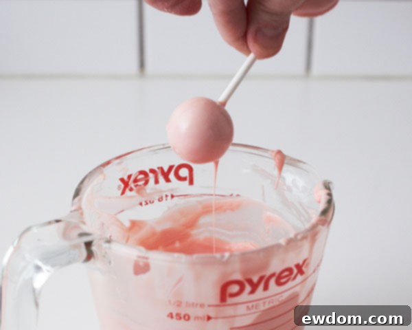 Dip the small cake balls to create the rattle handles and chill.