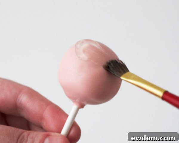 Apply piping gel to the top half of the large cake pop balls.