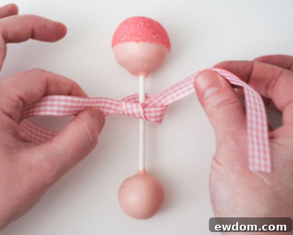 Finish baby rattle cake pops by tying a gingham bow.