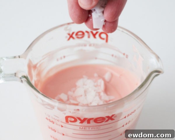 Melt pink candy coating and thin with paramount crystals.