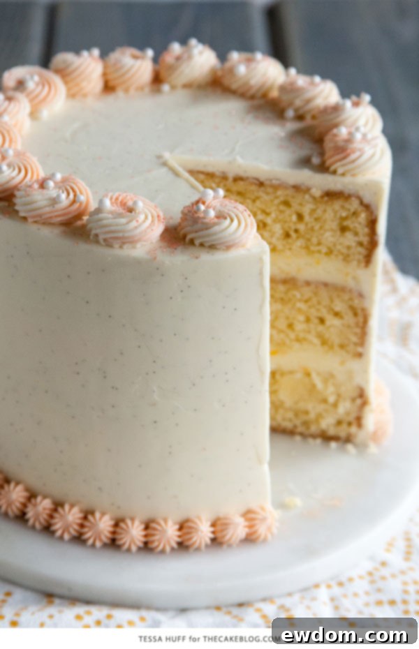 Slice of homemade Orange Creamsicle Cake with delicate rosettes