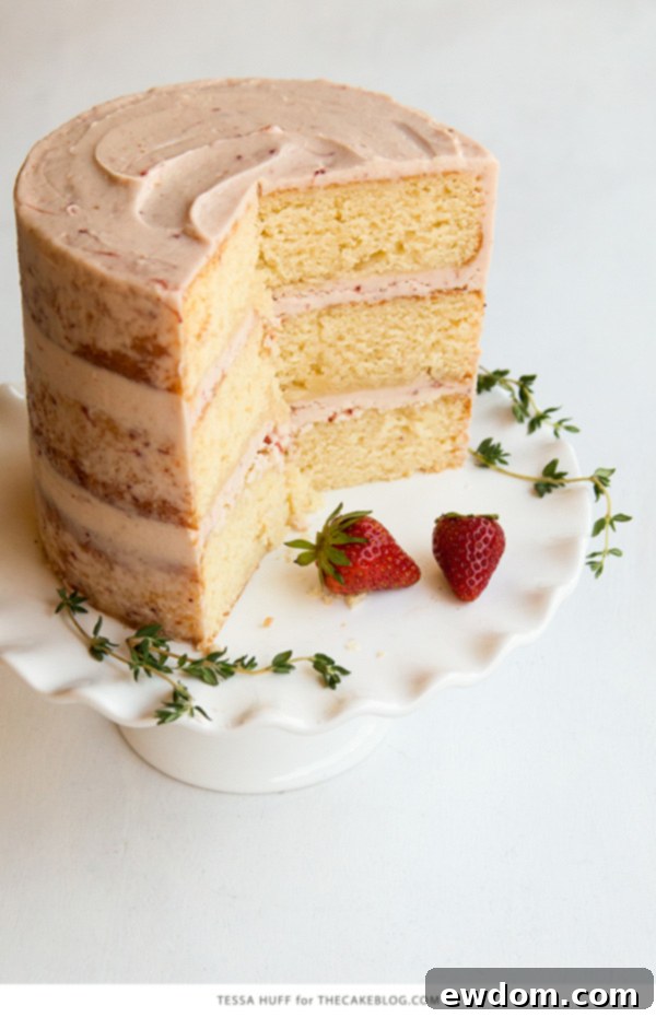 Thyme-Infused Strawberry Bliss 7 Two slices of Strawberry Thyme Cake on a white plate with fresh berries