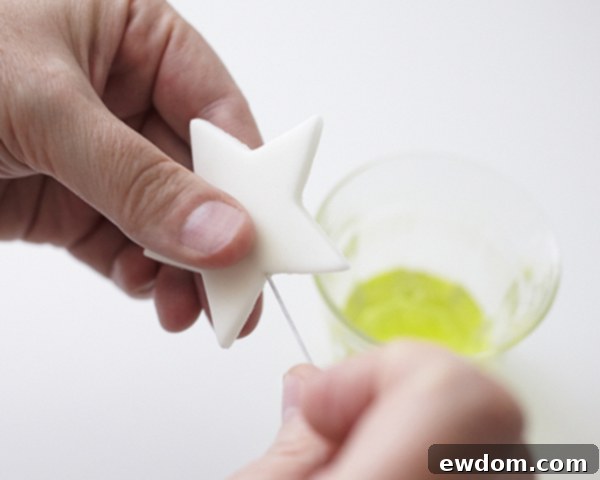 Inserting wire into a gumpaste star cake topper using egg white as an adhesive | by Cakegirls for TheCakeBlog.com