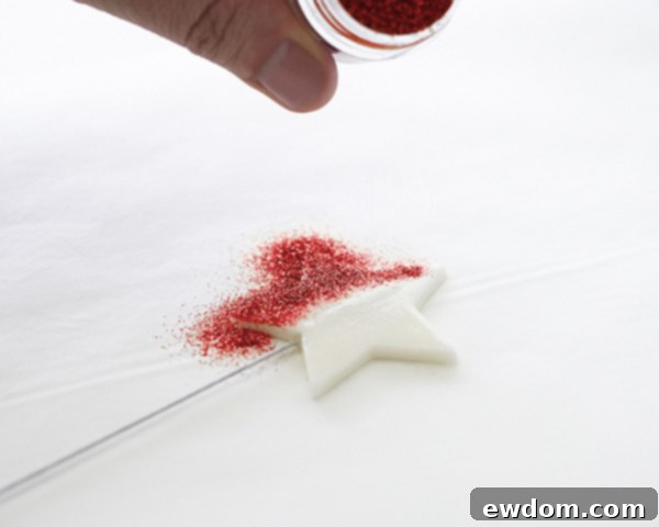 Close up of glitter being applied to a gumpaste star for a cake decoration | by Cakegirls for TheCakeBlog.com