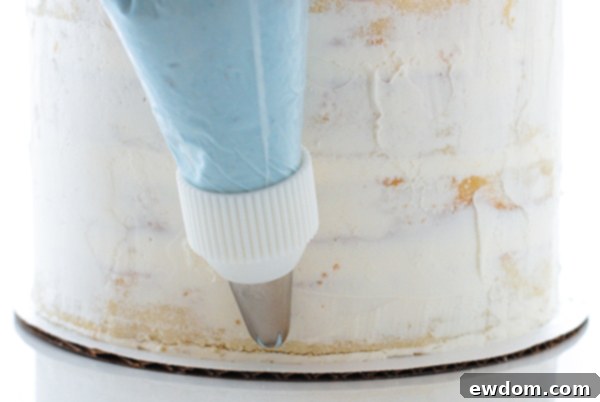 Starting to pipe buttercream ruffles at the base of the Cinderella cake