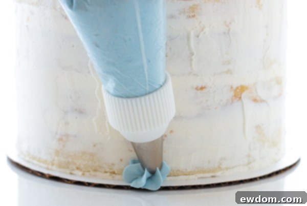 Piping buttercream ruffles up the side of the Cinderella cake, showing technique