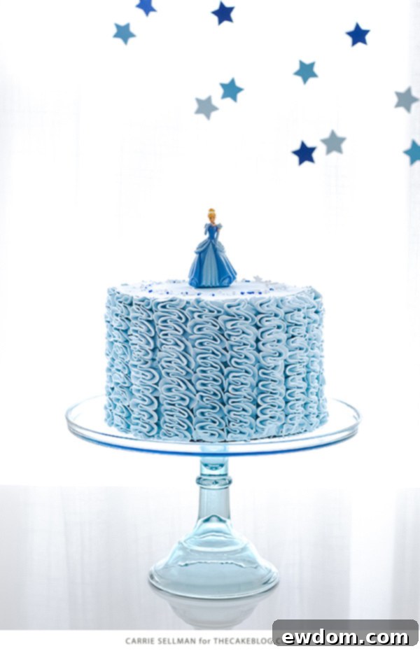 Stunning Cinderella birthday cake with delicate buttercream ruffles and a princess topper