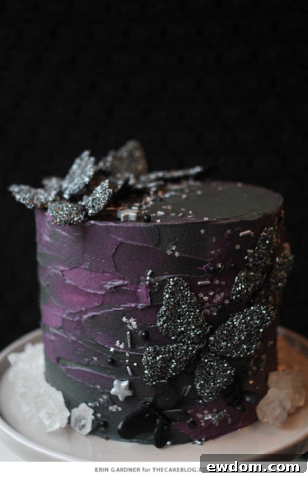 Decorated Halloween cake with black butterflies, silver stars, and sprinkles