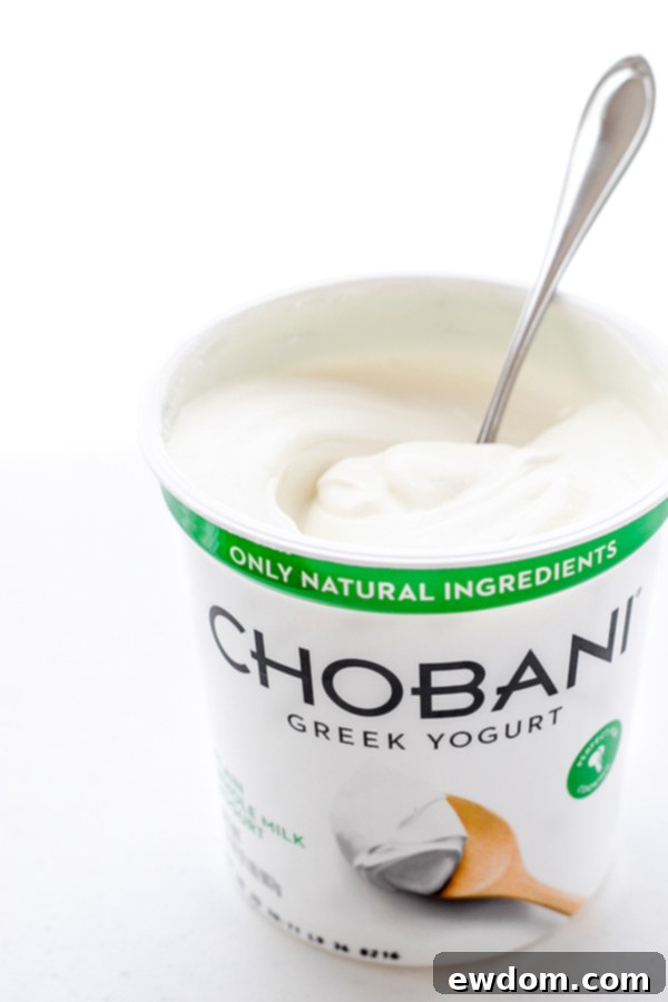 Sweet Plum Cake with Tangy Yogurt Cream 6 A perfectly sliced piece of Spiced Plum Cake topped with a dollop of whipped yogurt, ready for enjoyment