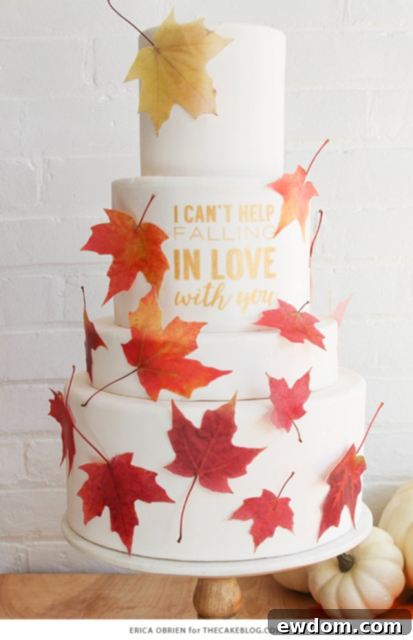 Artistic placement of gradient wafer paper leaves framing a gold quote on a multi-tiered autumn wedding cake
