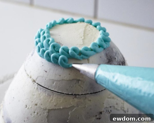 Piping horizontal rows of blue buttercream loops for the knitted hat texture