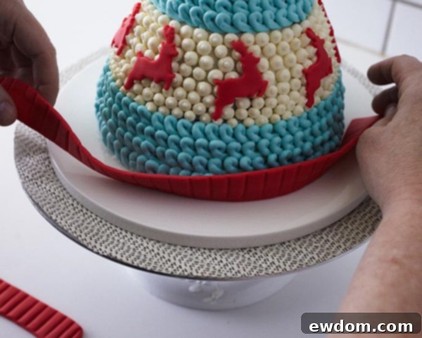 Attaching the textured fondant hat band around the base of the cake