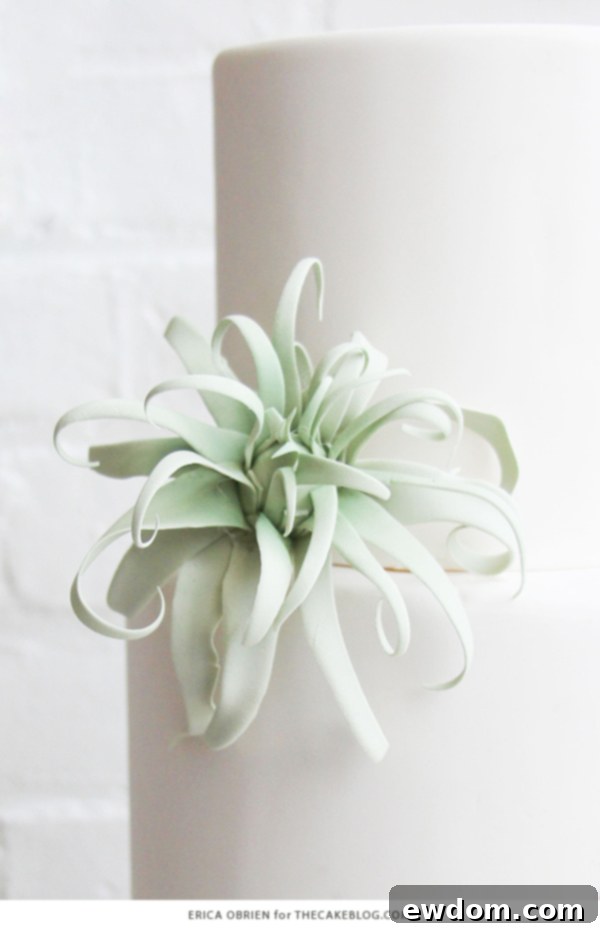 Lifestyle shot of the gold dipped wedding cake, styled with minimalist white dinnerware and gold accents, capturing a refined aesthetic.