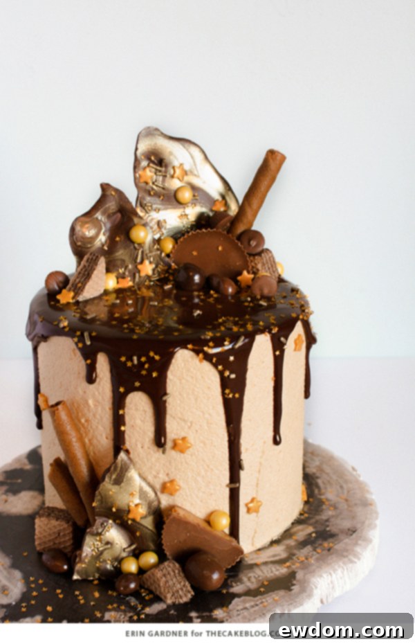 Finished drippy chocolate peanut butter cake adorned with ganache, chocolate shards, candies, and cookies, by Erin Gardner for TheCakeBlog.com