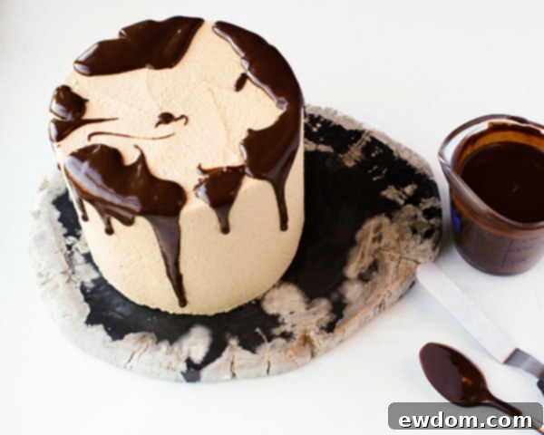 Spreading ganache on top of a chocolate drip cake with an offset spatula, by Erin Gardner