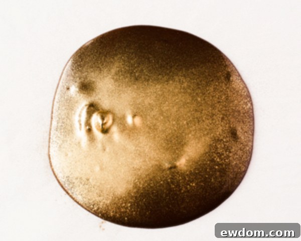 Dusting melted chocolate with edible gold luster dust for cake decoration, by Erin Gardner