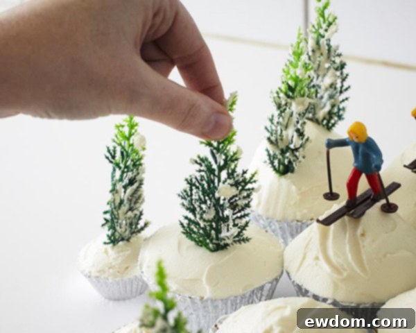 Arranging the buttercream-covered pine trees around the ski scene cupcakes to create a forest effect.