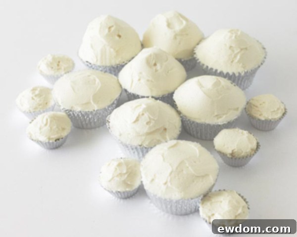 Another angle showing buttercream being smoothed onto cupcakes to create varied snowy terrain.