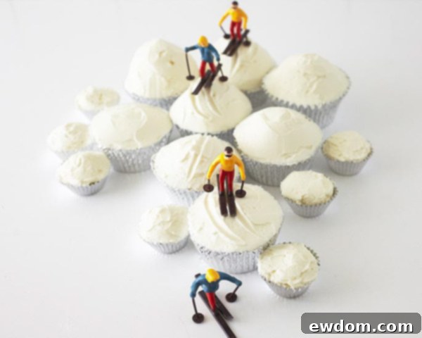 Miniature skiers being placed onto the buttercream ski trails on the cupcakes.