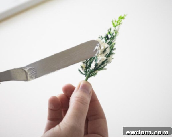 Pine tree novelties being decorated with buttercream before placement on the cupcake landscape.