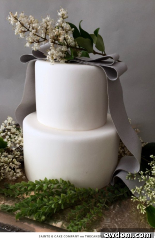 Elegant Two-Tier Wintry White Cake with Grey Grosgrain Ribbon, White Lilacs, and Meadow Greenery by Sainte G Cake Company | TheCakeBlog.com