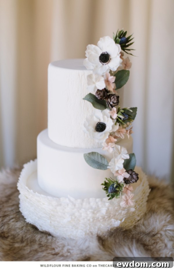 Natural Woodgrain Texture Winter Cake with Pinecones, Greenery, and White Blooms by Wildflour Fine Baking Co | TheCakeBlog.com