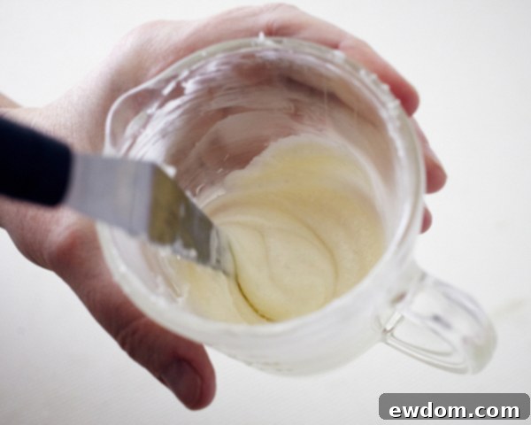 Blossom Cake Pops 8 Melting white candy coating in a microwave-safe bowl for dipping cake pop sticks.