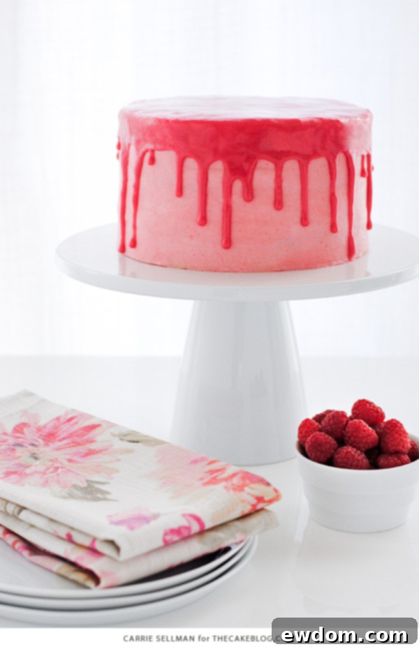 Pink Champagne Raspberry Dream 2 A beautifully decorated Raspberry Champagne Cake with a pink drip glaze, topped with fresh raspberries and cream, perfect for Valentine's Day.