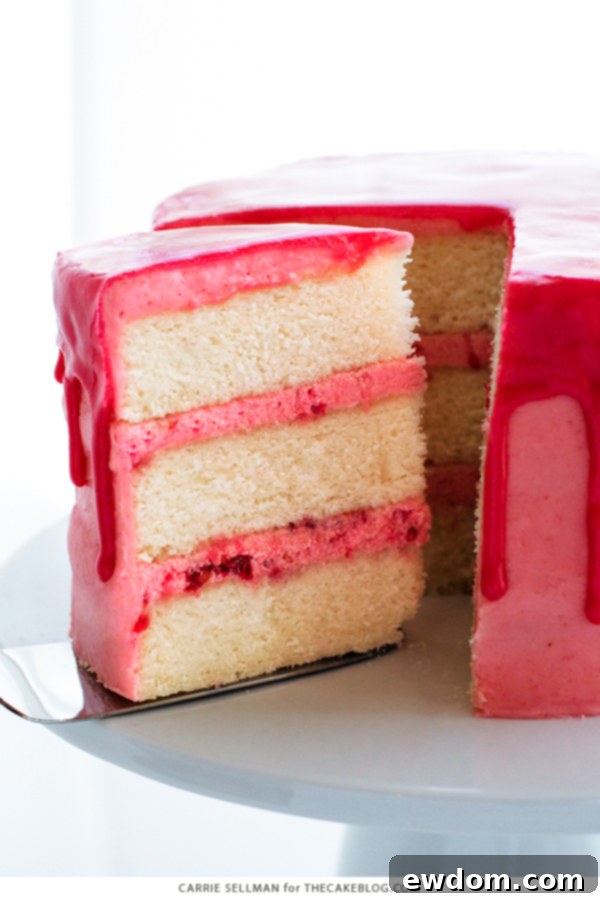 Pink Champagne Raspberry Dream 3 Close-up of the Raspberry Champagne Cake showing the delicate pink drip glaze and vibrant fresh raspberries on top.