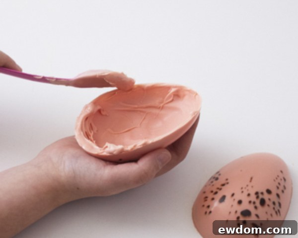 Step 7: Joining the two halves of a chocolate egg with melted candy coating.